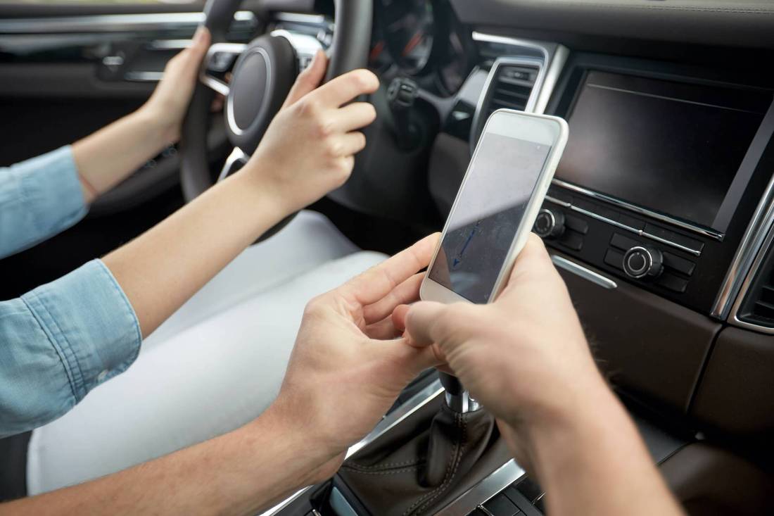 beifahrer mit handy in der hand