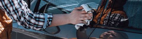 mann putzt und poliert autoscheiben