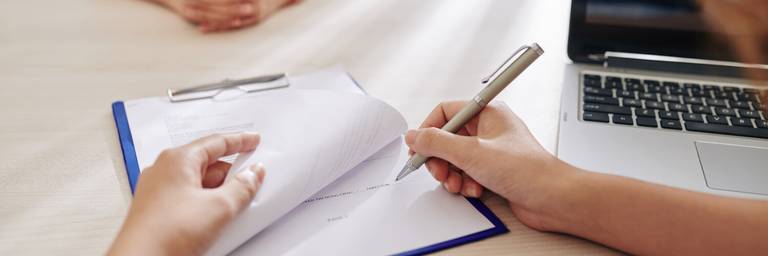 person unterschreibt formulare