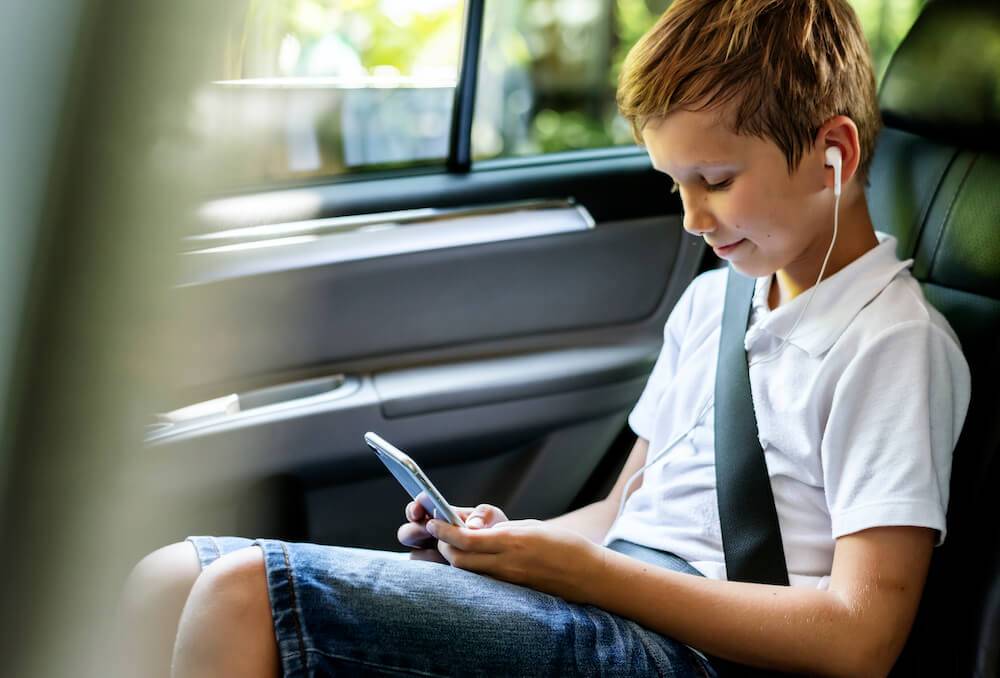 kind mit handy sitzt im auto kind mit handy sitzt im auto