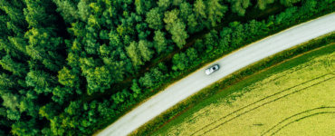 auto zwischen wiese und wald