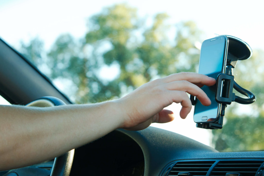 hand mit handyhalterung im auto