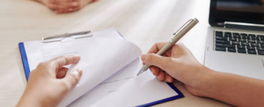 person unterschreibt formulare