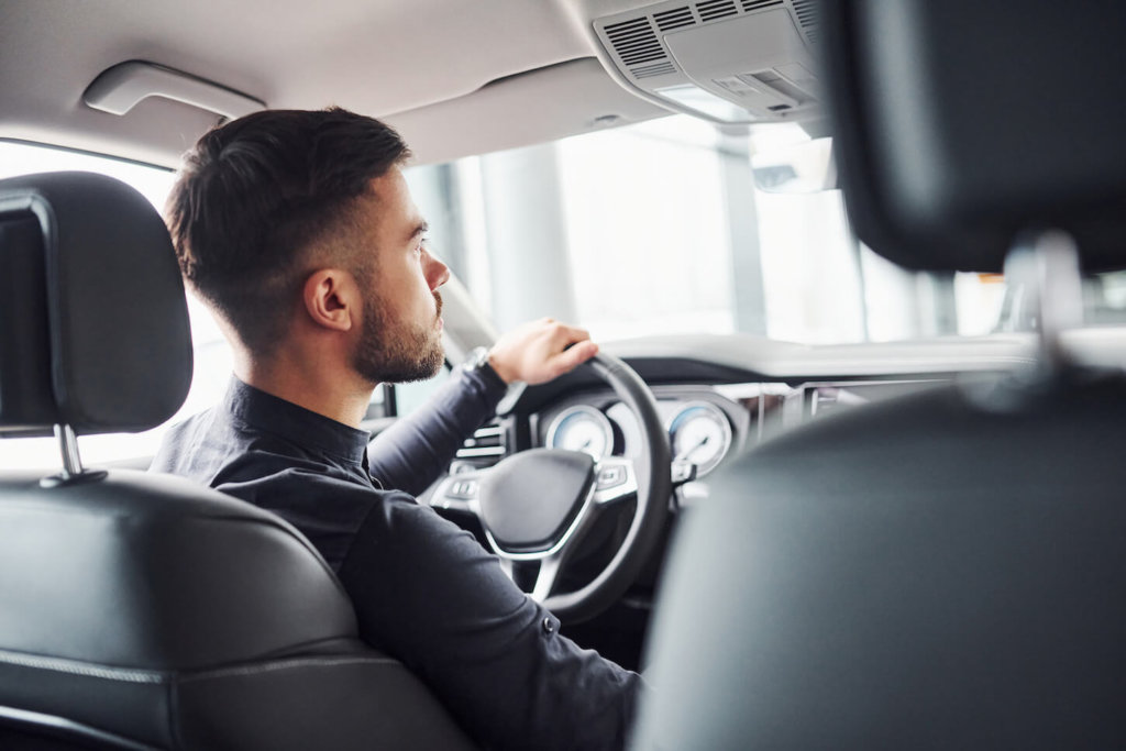 mann testet fahrzeug bei probefahrt