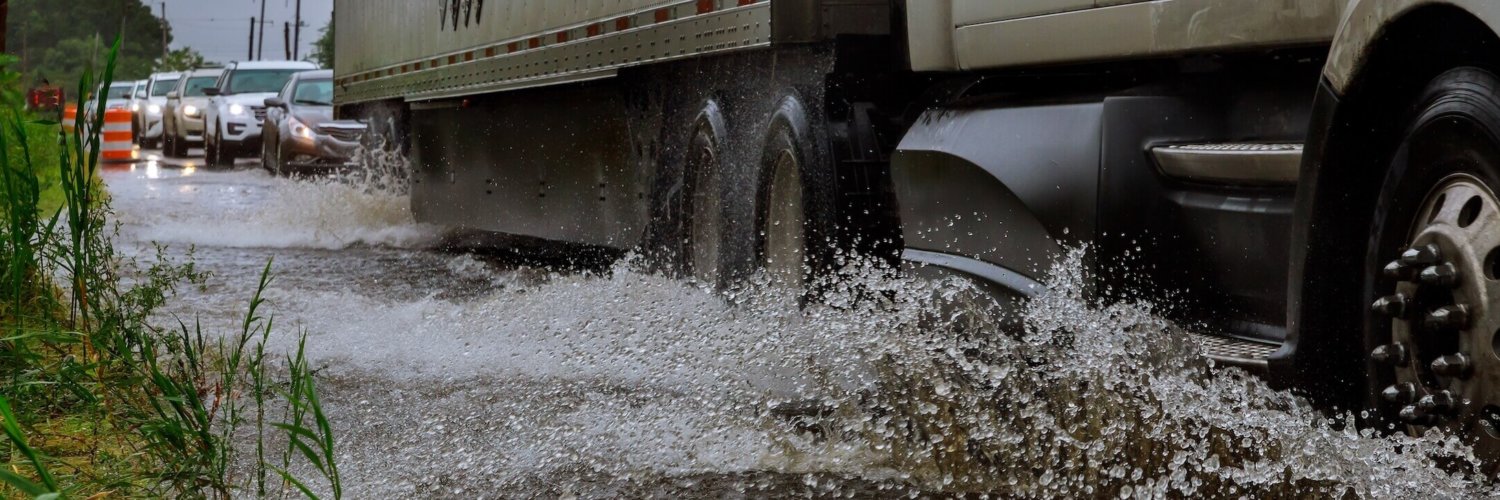 Lkw und Pkw auf nasser Fahrbahn