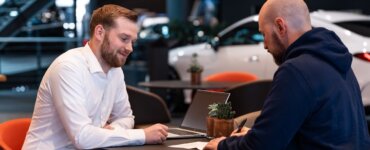 Leasingnehmer und Händler unterschreiben Leasingvertrag